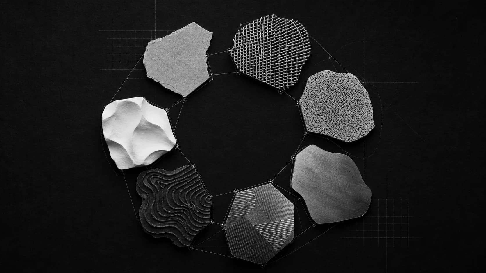 Seven distinct monochrome material forms collaborating around a shared center